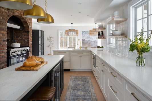 white inset shaker kitchen with gold accents and brick wall in Amagansett, NY designed by DirectCabinets.com