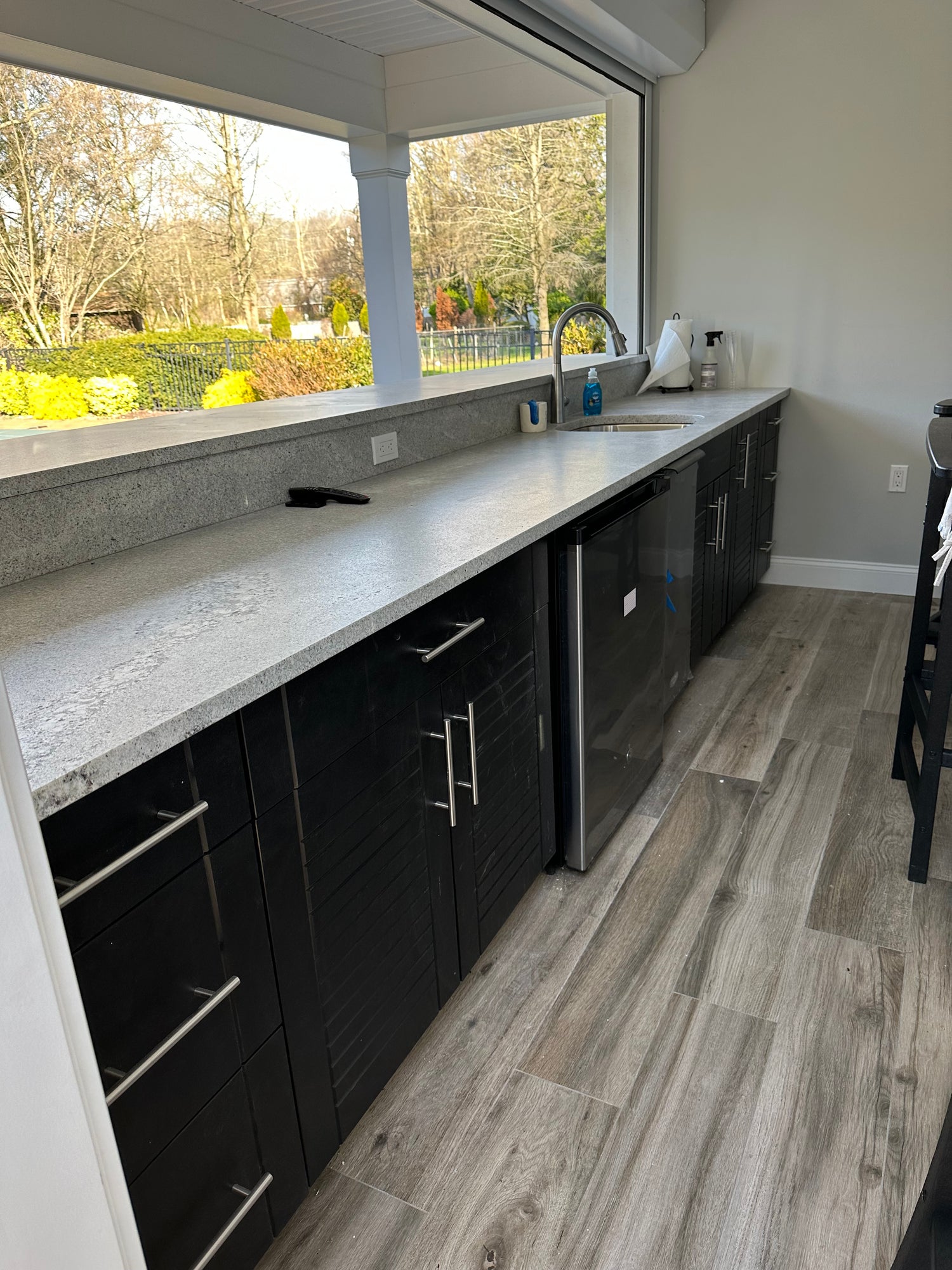 Black outdoor weatherstrong cabinetry for a pool house bar area.