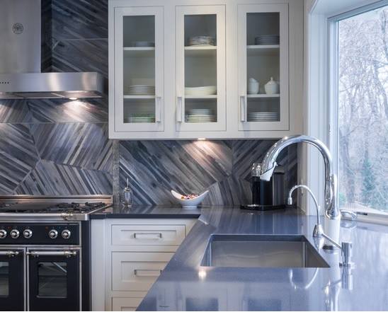White shaker cabinetry with blue countertops and a blue funky backsplash.